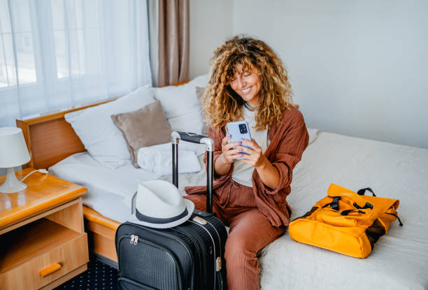 istock Woman using phone in a hotel room 2199842041