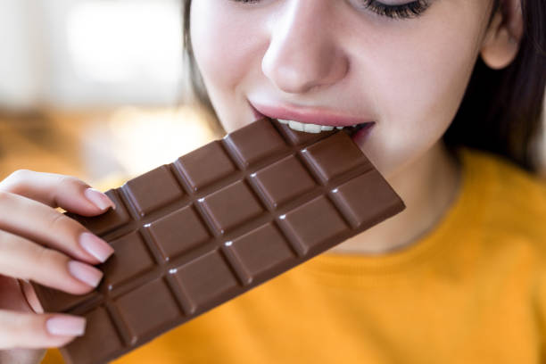 istock Female eating tasty chocolate bar 2199842495