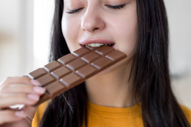 istock Female eating tasty chocolate bar 2199842565