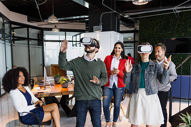istock Group of young latin business people using virtual reality glasses during meeting testing VR headset at office in Mexico Latin America. hispanic people at working at job 2199842895