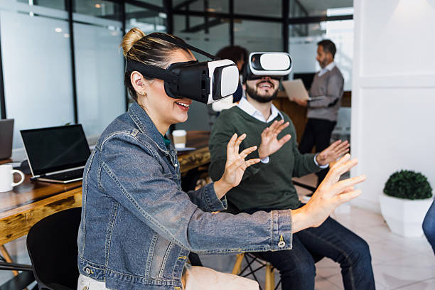 istock Group of young latin business people using virtual reality glasses during meeting testing VR headset at office in Mexico Latin America. hispanic people at working at job 2199842922