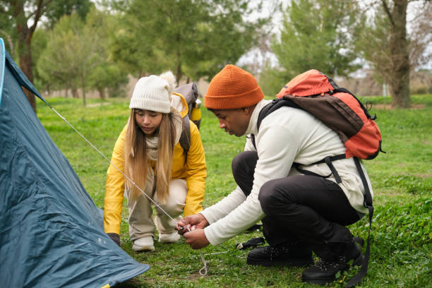 istock Hikers pitching tent in a forest campsite during their adventure 2199843838