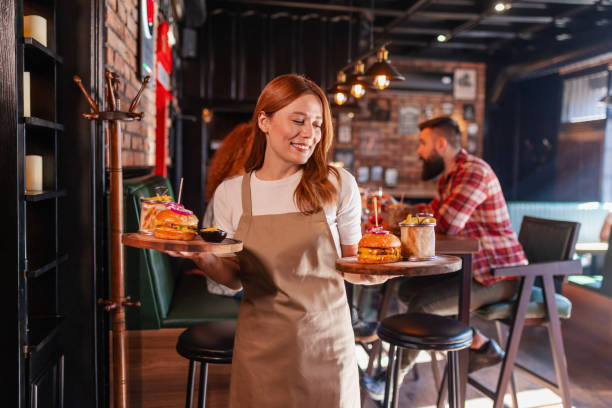 istock Serving Happiness: A Beaming Waitress with Gourmet Meals 2199848009
