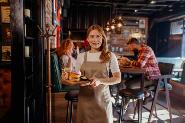 istock Serving Happiness: A Beaming Waitress with Gourmet Meals 2199848018