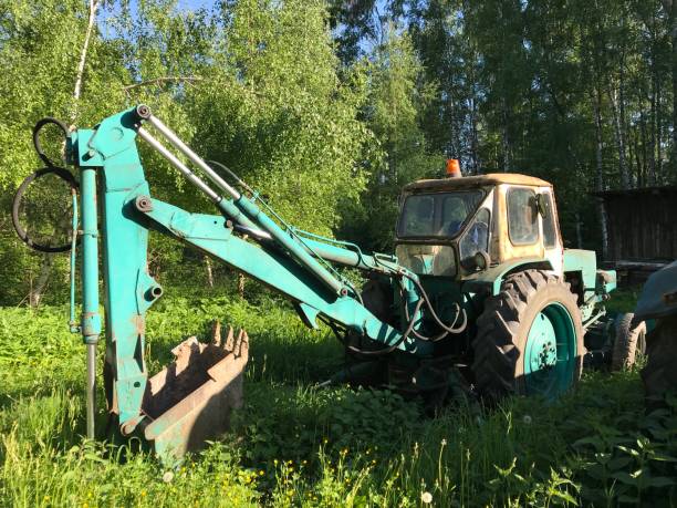 istock An old blue excavator stands in a field and waits for work 2199850795