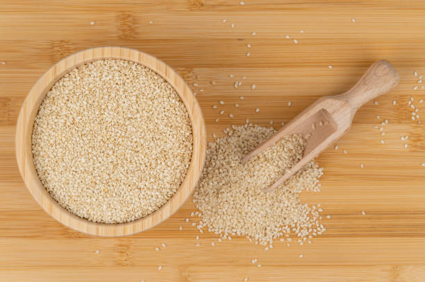 istock Sesame seeds in a bowl with a wooden scoop on a bamboo surface 2199850979