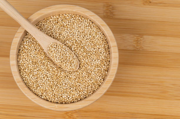 istock Quinoa seeds in a wooden bowl with a spoon on a bamboo surface 2199851121