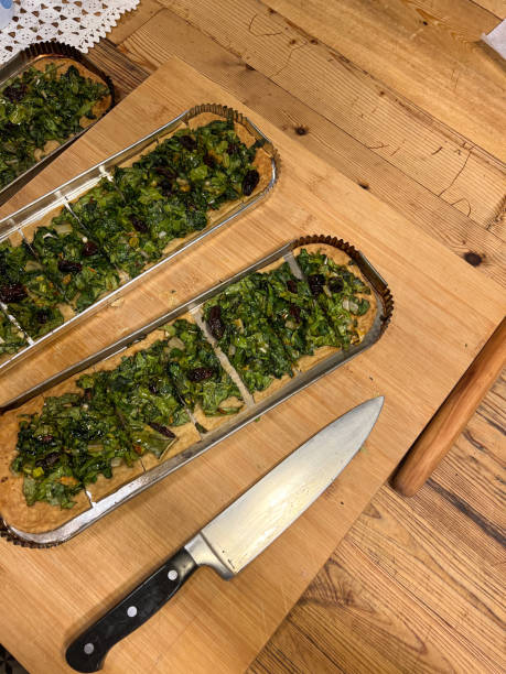 istock Traditional Spanish coca pizza dish prepared in rustic Mallorca kitchen with dates, olives and green spinach leaves 2199851598