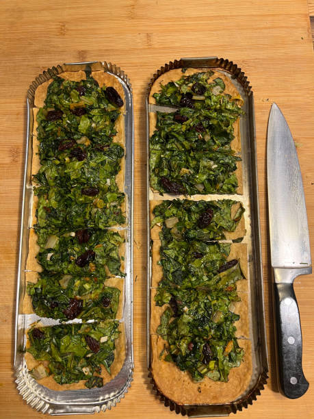 istock Traditional Spanish coca pizza dish prepared in rustic Mallorca kitchen with dates, olives and green spinach leaves 2199851614