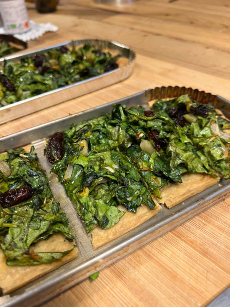 istock Traditional Spanish coca pizza dish prepared in rustic Mallorca kitchen with dates, olives and green spinach leaves 2199851622