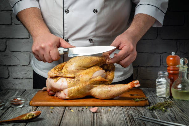 istock In a warm, inviting kitchen, a chef skillfully slices into a raw chicken, showcasing culinary expertise. European cuisine 2199855504