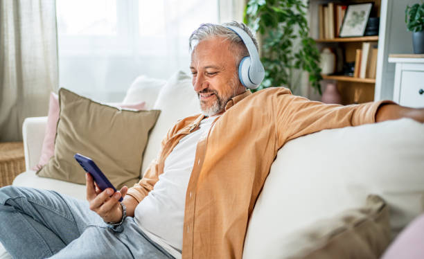 istock Mature man enjoying music at home 2199856113