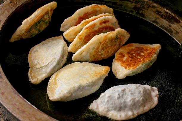 istock Golden-brown fried dumplings on skillet 2199859922