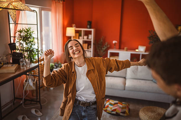 istock girlfriend dance energetically with her boyfriend at home 2199870011