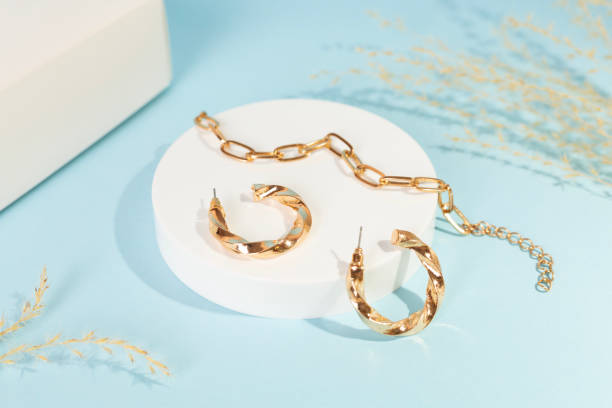 istock Golden earrings with decor on color background 2199872338