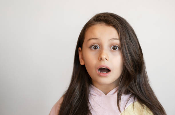 istock Cute little girl making a shocked face over white background 2199879426