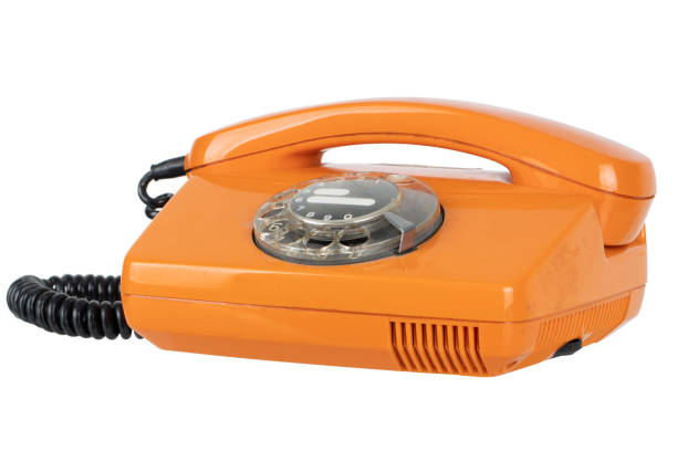 Old vintage orange rotary phone isolated on white background