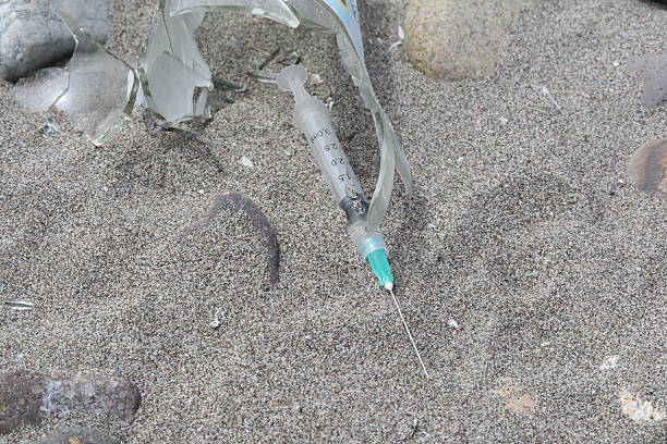 istock syringe and beer bottle on the beach 2199888422
