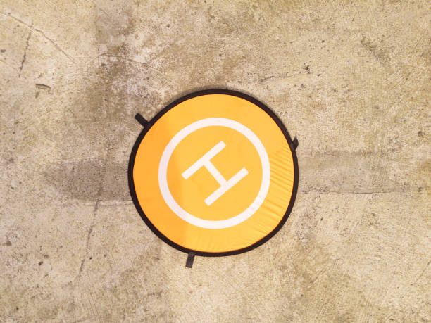 A round drone pad with orange color with cement floor background