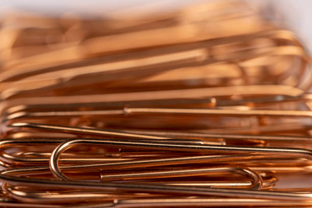 istock large-sized copper paper clips lie on white blank paper 2199891178