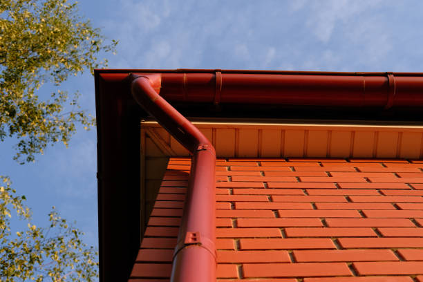 istock Rain gutter from the roof of red brick house. Metallic guttering system. 2199892237