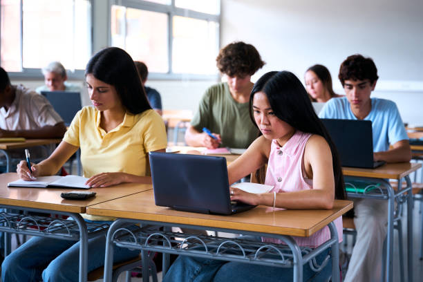 istock Cheerful Smiling Asian high school student girl using a laptop computer at class 2199898023