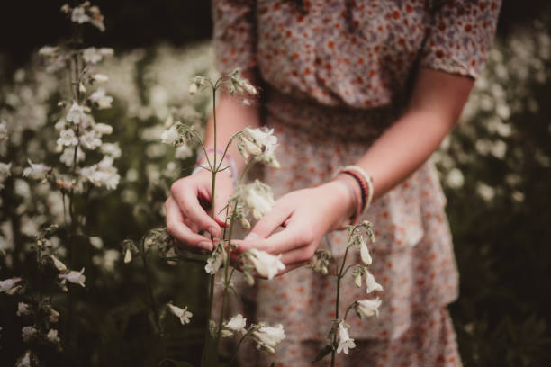 Girl in floral dress smelling wildflowers
