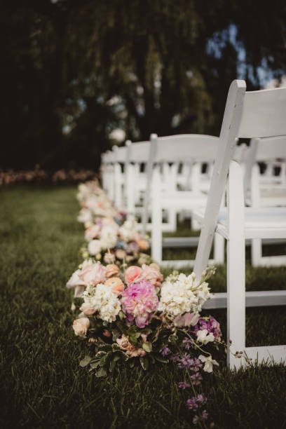 istock Wedding ceremony aisle with white chairs and flower arrangements 2199900838