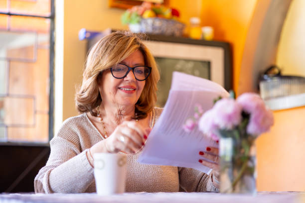 istock Retired woman viewing a documents in her dining room 2199902301