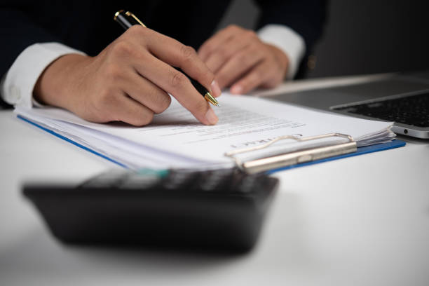 istock Business agreement, businessman checking and signing a document, professional desk, office equipment, calculating expenses, modern business, finance and law 2199904393