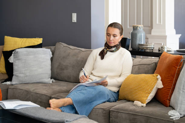 istock Mature woman on the couch analyzing documents at home 2199905209