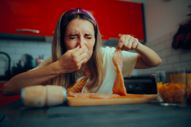 istock Cooking Woman Holding Meat Feeling Disgusted by Its Smell 2199905727