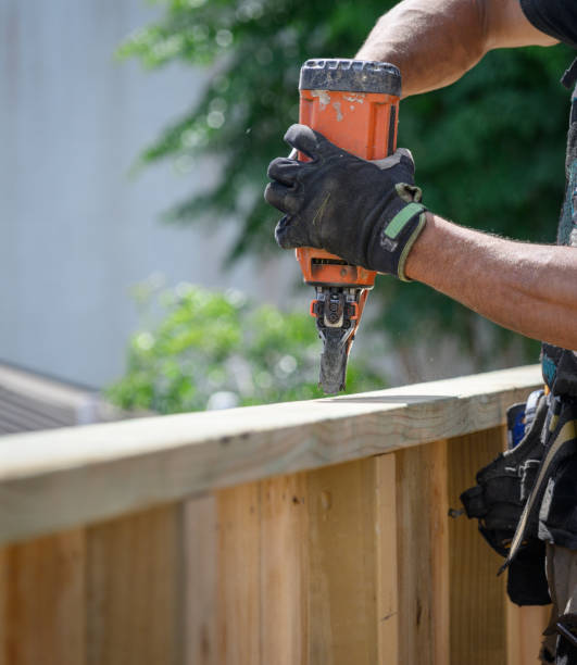 istock Hands of a professionally equipped builder working on fence using a nail gun construction tool. 2199913465