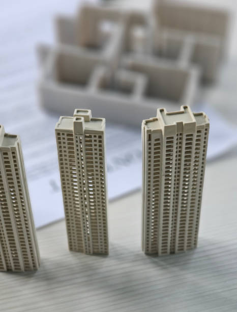 istock Miniature skyscrapers displayed on a desk with architectural plans 2199915026