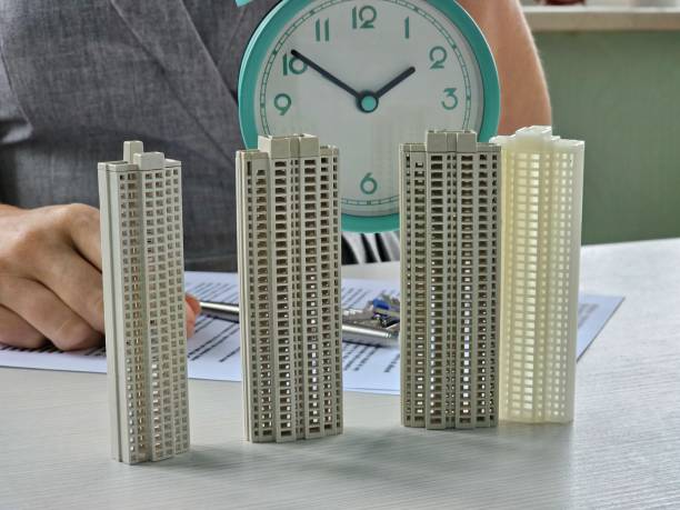 istock Scale models of buildings displayed on table with a clock, highlighting architectural design and project planning concept 2199915433