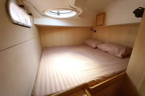 istock Cozy bed on a voyage boat with a window overhead with natural light 2199915607