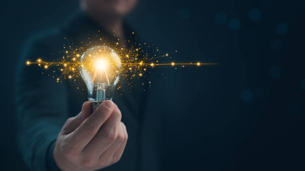 istock Innovation through ideas and inspiration ideas. Human hand holding light bulb to illuminate. 2199918346