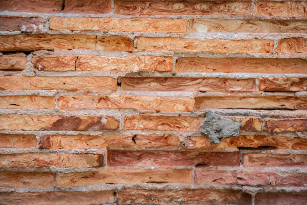 A close-up of a weathered brick wall with visible mortar and subtle variations in brick color and texture. The image conveys a sense of age, history, and rustic charm.