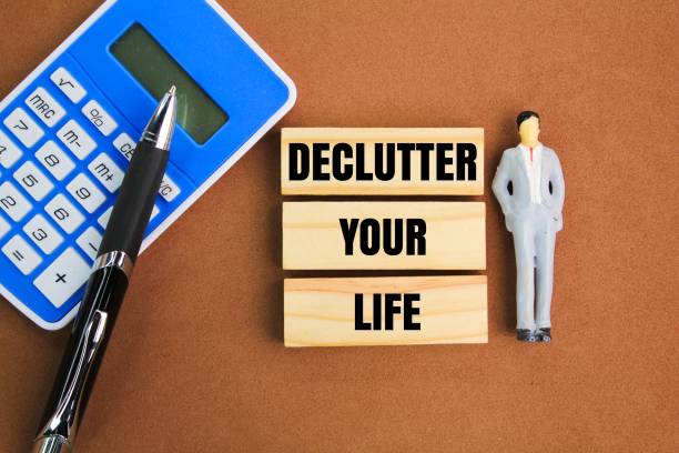 istock miniature people, calculator, pen and stick with the words Declutter Your Life 2199920052