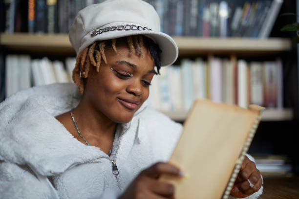 istock young African descent lady reading book at cafe 2199921829