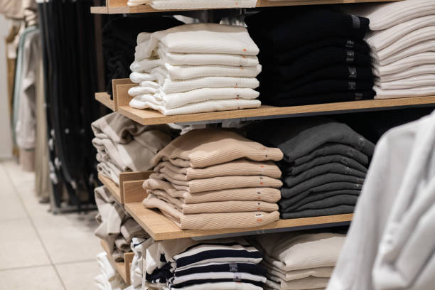 istock Organized shelves displaying neatly folded sweaters in neutral and dark tones, emphasizing cozy and minimalist fashion in a retail store. 2199926033