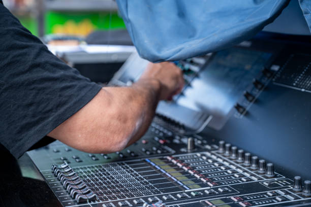 istock The arm of a sound engineer working on a mixing board. 2199926735