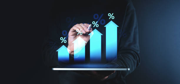 istock Businessman interacting with growth chart featuring upward arrows and percentages on digital tablet, symbolizing success and financial growth. 2199927103