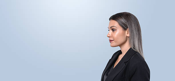 istock Profile of a professional woman in a blazer on a light blue back 2199927203