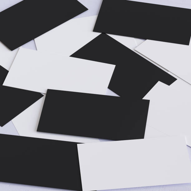 Black and white business cards are scattered all over the white table