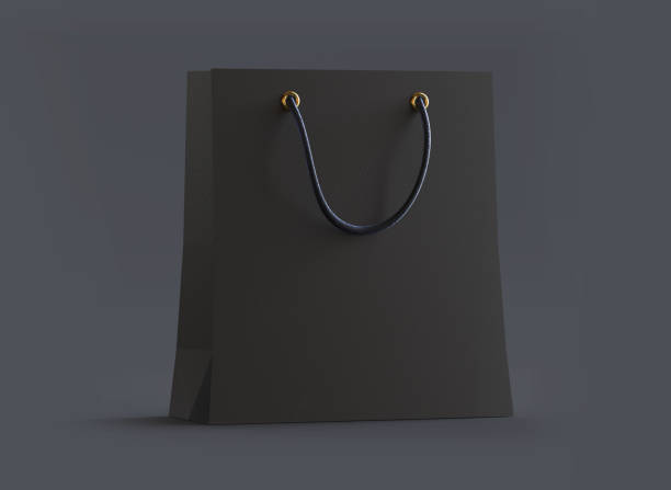 Black shopping bag mockup with handles isolated on dark background,