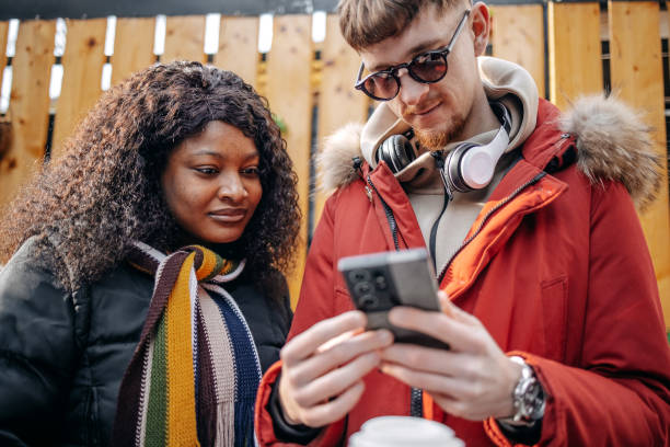 istock University students on a coffee break outdoor at sidewalk cafe looking at mobile phone 2199928599