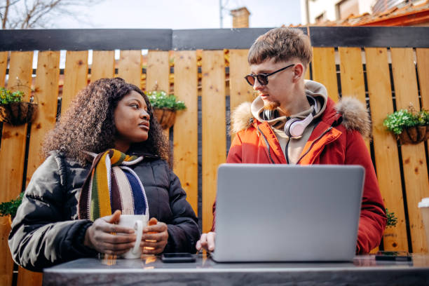 istock University students on a coffee break outdoor at sidewalk cafe looking at laptop 2199928717