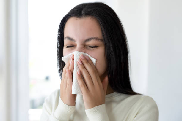istock Woman blowing her nose 2199931218