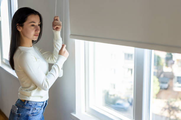 istock Beautiful woman opening the curtains 2199931221